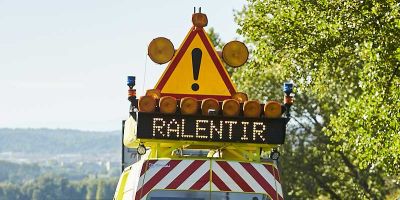 Patrouilleur en action avec signalisation de ralentissement en journée